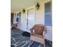 Close-up of the front porch with rocking chairs, decorative lighting and stone tile floor at 411 W Raleigh St, Siler City, NC 27344