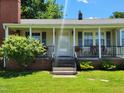Inviting front porch with comfortable seating, decorative lamps, and a secure screen door at 411 W Raleigh St, Siler City, NC 27344