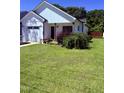Beautiful white home features a green lawn, a two-car garage, and tasteful landscaping at 451 N Lincoln St, Benson, NC 27504