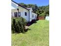 Spacious, well-maintained lawn showcases the side of the home and a wooden fence at 451 N Lincoln St, Benson, NC 27504