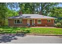 Inviting red brick ranch-style home with a lush green lawn and mature trees, offering classic charm and curb appeal at 503 Tarleton Ave, Burlington, NC 27215