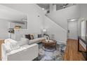 Open-concept living room with staircase, neutral colors, and wood flooring for a modern feel at 5300 Roan Mountain Pl, Raleigh, NC 27613