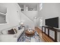 Spacious living room featuring a staircase, high ceilings and an entertainment area with a television at 5300 Roan Mountain Pl, Raleigh, NC 27613