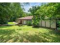 Home exterior featuring a lush green lawn with mature trees, offering a serene setting at 5301 Thayer Dr, Raleigh, NC 27612