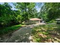 Exterior of the home featuring a long driveway leading to the property surrounded by trees at 5301 Thayer Dr, Raleigh, NC 27612