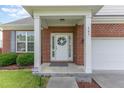 Close-up of the welcoming front entrance with a wreath on the white door and brick facade at 543 Callandale Ln, Durham, NC 27703