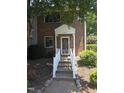 Inviting entrance to a red brick townhome with well-maintained landscaping at 5893 Shady Grove Cir, Raleigh, NC 27609