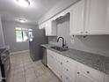 Bright kitchen with stainless steel appliances, granite countertops and white cabinets at 5893 Shady Grove Cir, Raleigh, NC 27609