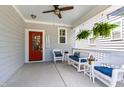 Cozy front porch featuring comfortable seating, ferns, and a striking red door at 690 Great Ridge Pkwy, Chapel Hill, NC 27516
