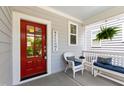 Inviting porch with red door, stylish white wicker furniture, and hanging fern accents at 690 Great Ridge Pkwy, Chapel Hill, NC 27516