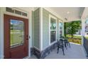 Close-up of the front porch featuring a detailed front door, seating area and view of the neighborhood at 8341 Running Fern Way, Willow Springs, NC 27592