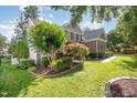 Beautiful home featuring brick facade, lush greenery, and well-maintained lawn and landscaping at 9021 Winged Thistle Ct, Raleigh, NC 27617