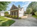 Features a brick and siding design, well-manicured lawn, and a paved driveway leading to a garage at 9021 Winged Thistle Ct, Raleigh, NC 27617