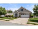 Attractive home featuring neat landscaping, stone details, and an attached garage at 102 Mikaila Dr, Gibsonville, NC 27249