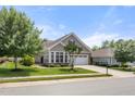 View of a well-kept home with a beautiful lawn, complemented by mature trees at 102 Mikaila Dr, Gibsonville, NC 27249