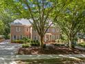 Charming brick home with mature trees, manicured landscaping, and inviting entryway creates a picturesque setting at 1105 Tazwell Pl, Raleigh, NC 27612