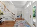 Inviting foyer with hardwood floors, elegant staircase, and a view into the living room exudes classic charm at 1105 Tazwell Pl, Raleigh, NC 27612