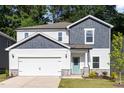 Charming two-story home featuring a 2-car garage, white siding and a delightful, turquoise front door at 1113 Umstead Grove Way, Durham, NC 27712
