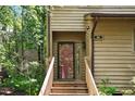 Close-up of the front entrance with wood door and staircase to the home at 113 Twisted Oak Pl, Durham, NC 27705