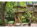 Charming townhouse with wood siding, lush landscaping, and inviting wooden staircase at 113 Twisted Oak Pl, Durham, NC 27705