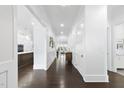 Inviting hallway with gleaming hardwood floors and crisp white trim and doors at 129 Damsire Way, Cary, NC 27513