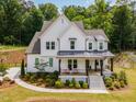 Attractive two-story home featuring a cozy front porch, green lawn, and a well-maintained garden at 1344 Legend Oaks Dr, Chapel Hill, NC 27517