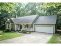 Attractive single-story home featuring an attached garage, covered front porch, and lush green lawn at 140 Baron Cir, Youngsville, NC 27596