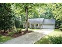Inviting home with a long driveway, well-maintained landscaping, and mature trees providing shade at 140 Baron Cir, Youngsville, NC 27596