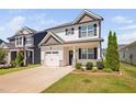 Charming two-story home with a white garage door, stone accents, and a manicured lawn on a sunny day at 147 Sunfish St, Smithfield, NC 27577