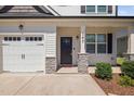 Inviting front entrance with a black door, stone pillar accents, and clear house number on a sunny day at 147 Sunfish St, Smithfield, NC 27577