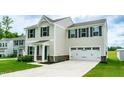 Inviting two-story home featuring a two-car garage, landscaped yard and charming front entrance at 1476 Burgundy Bluff Ln, Zebulon, NC 27597
