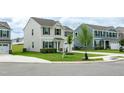 View of the home exterior with adjacent home, complemented by a young tree in the front yard at 1476 Burgundy Bluff Ln, Zebulon, NC 27597