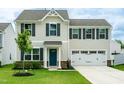 Inviting two-story home with a two-car garage, complemented by fresh landscaping and a well-manicured lawn at 1476 Burgundy Bluff Ln, Zebulon, NC 27597