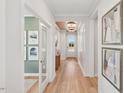 Bright hallway with decorative accent wall, wood flooring, and views to other rooms at 160 Serene Xing, Fuquay Varina, NC 27526