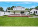 Charming two-story home featuring a classic white exterior, brick foundation, and lush green lawn at 163 W Lillington St, Angier, NC 27501