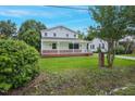 Inviting home with a covered front porch, a well-manicured lawn, and mature trees at 163 W Lillington St, Angier, NC 27501