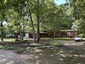Exterior of a home with a circle drive and multiple buildings surrounded by trees at 194 John Mitchell Rd, Youngsville, NC 27596