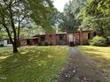 A single story brick home with a chimney and a sidewalk leading to the front door at 194 John Mitchell Rd, Youngsville, NC 27596