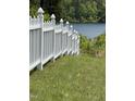 A white picket fence borders a grassy lawn leading to the lake view beyond at 2011 Bowmantown Rd, Roxboro, NC 27574