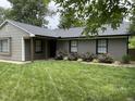Single story home with updated exterior, landscaping, and healthy green grass at 205 Woodhaven Dr, Burlington, NC 27217