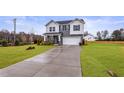 Charming two-story home with gray and white siding, a two-car garage, and a manicured lawn at 21 Whistling Way # 17, Lillington, NC 27546
