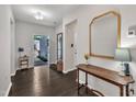 Inviting foyer with dark hardwood floors, decorative mirror, and a view of the front door at 2626 Nassau Trce, Fuquay Varina, NC 27526