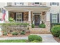 Inviting front porch with stone accents, manicured landscaping, and a welcoming entrance with clear address numbers at 2941 Grandview Heights Lane Ln, Raleigh, NC 27614