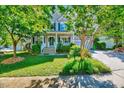 Beautiful two-story home featuring mature trees, a lush lawn, and a welcoming front porch at 3217 Enchanting Way, Raleigh, NC 27616