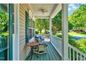 Relaxing covered front porch featuring comfortable seating, classic railings, and views of the well-manicured landscape at 3217 Enchanting Way, Raleigh, NC 27616