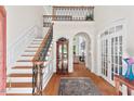 Bright foyer with hardwood floors, staircase with decorative iron railing and arched doorways at 3606 Dairy Pond Pl, Durham, NC 27705