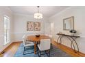 Dining room with hardwood floors, area rug, round table, and elegant decor at 4309 Omni Pl, Raleigh, NC 27613