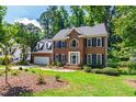 Stately brick home with blue shutters, lush lawn and mature trees at 4309 Omni Pl, Raleigh, NC 27613