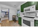 Well-equipped kitchen with updated appliances, green cabinets, and an adjacent breakfast nook at 4600 Townesbury Ln, Raleigh, NC 27612