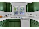 Bright kitchen with stainless steel sink, green cabinets, marble countertops, and a window view at 4600 Townesbury Ln, Raleigh, NC 27612
